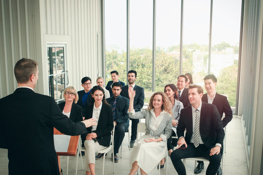 Group of business people sitting on conference together listening to the speaker giving a speech in the meeting room seminar, successful businessman sharing experiences, the audience applauded and cla