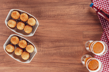 Brazilian appetizer deep fried cheese croquette with two glasses of beer - Bolinha de queijo in top view