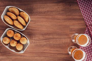 Brazilian appetizer deep fried cheese and beef croquette with two glasses of beer - Bolinha de queijo and risolis de carne in top view