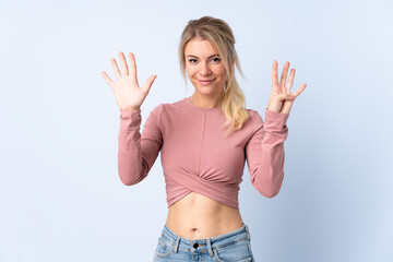 Fototapeta na wymiar Blonde woman over isolated blue background counting nine with fingers