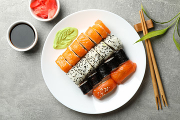 Plate with sushi rolls on gray background. Japanese food