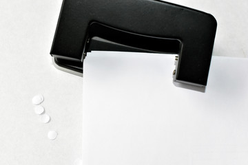 A clerical hole punch in the business with a hand a dollar and paper