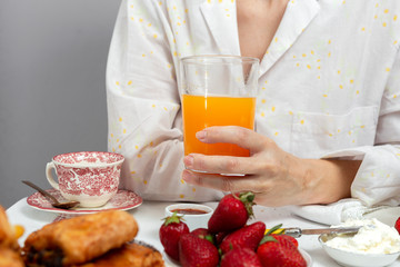 Obraz na płótnie Canvas Unrecognizable woman having breakfast in pajamas at home in quarantine