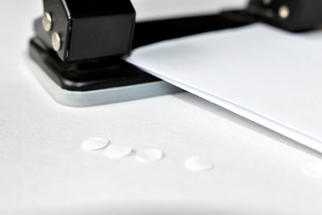 A clerical hole punch in the business with a hand a dollar and paper