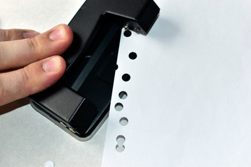 A clerical hole punch in the business with a hand a dollar and paper