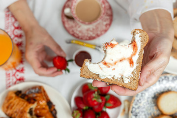 Unrecognizable woman having breakfast in pajamas at home in quarantine