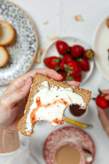 Unrecognizable woman having breakfast in pajamas at home in quarantine