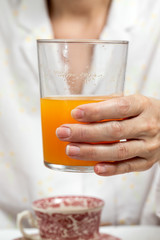 Unrecognizable woman having breakfast in pajamas at home in quarantine