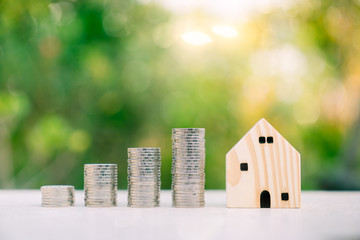 Wood house model and row of coin money on nature background, Real Estate market, Trading Estate, Mortgage Concepts