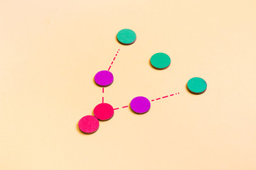 wooden multi-colored circles on a yellow background, social distance concept, the spread of coronavirus, quarantine and pandemic 2020