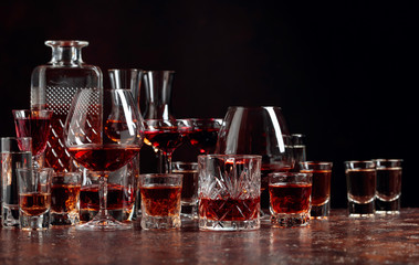 Set of strong alcoholic drinks in glasses on a dark background.
