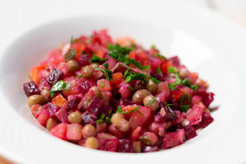 Vinegret beetroot salad close up in  plate on white wooden background