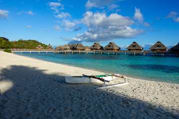Overwater Bungalows in Tropical Blue Lagoon with Outrigger on Beach in Foreground Bora Bora French Polynesia