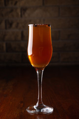 Glass of alcoholic drink with coffee grains on a wooden old table
