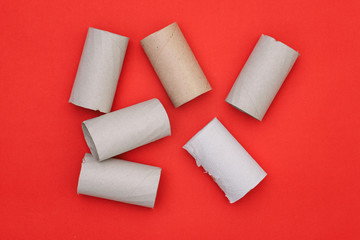Round cardboard tubes on a red background. Toilet paper. Rubbish waste for processing.