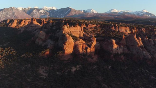 Drone Aerial Reveal Shot of Desert Canyon & La Sals Near Moab, Utah U.S.A. Above Desert in Summertime at Sunset with Mountains