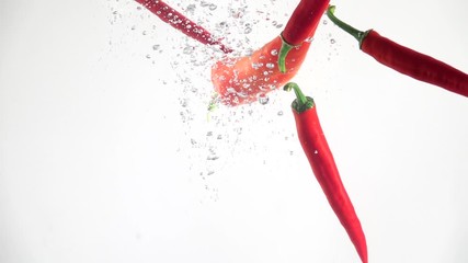 Hot red chilli peppers falling into the water on a white background. Slow motion - Powered by Adobe