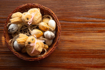 Nest with eggs, cute easter fluffy bunnies on wooden background