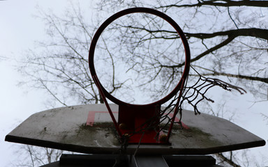 Fototapeta na wymiar Outdoor basketball hoop with torn net bottom view