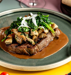 beef steak garnished with sauteed mushroom and spinach