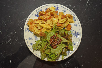 Omelette pommes de terre et salade lardons dans l'assiette.