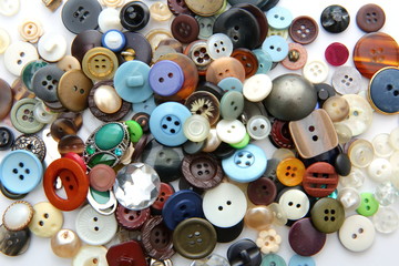 Different colors and shapes of plastic buttons scattered on the table.