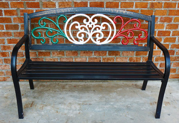 Metal alloy park bench chair painted in Italian flag colors outside an Italian restaurant.