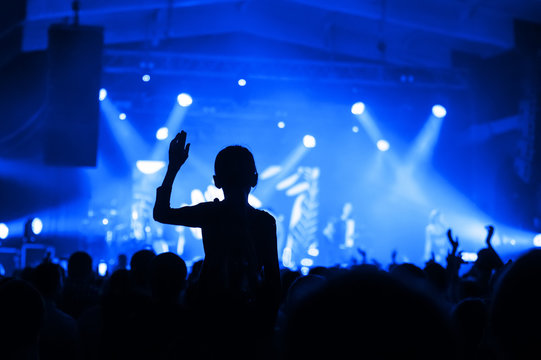 silhouette of a girl in a concert crowd in front of the stage. fanaticism from a music group. banner for a concert festival