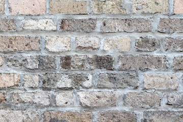 Closeup of brick wall, gray and brown rough bricks. Mortared joints. Indonesian alleyway, Denpasar, Bali, Indonesia.
