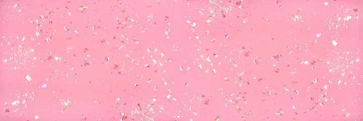 Pearl confetti on pink background. Flat lay, top view.