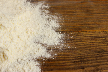 Scattered flour on a brown wooden table. Kitchen, baking, cooking concept.