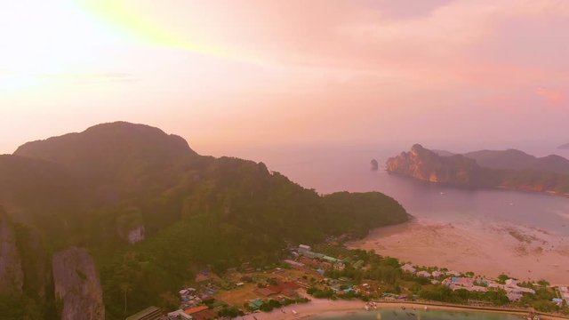 Panorama of Phi Phi island, Krabi province, Thailand. Spectacular color sunset over the sea and islands. Amazing twilight in the tropics and calm Indian Ocean. Aerial 4k view