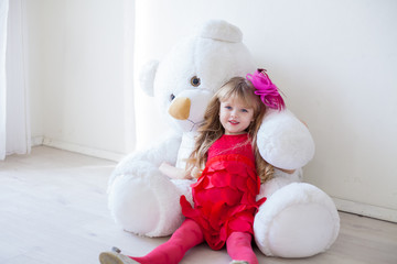 Little beautiful girl on holiday with white bear toy