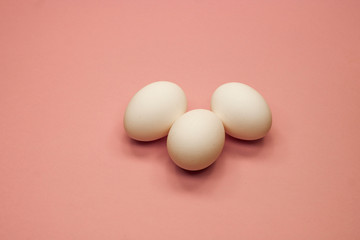three eggs on a pink background