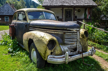Image of rusted abandoned an old broken car in Carpathian village
