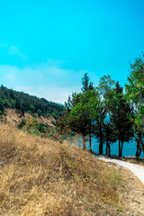 Fototapeta na wymiar Beautiful blue sky, trees, mountain and trail in UNESCO WHS Ohrid, North Macedonia. August, 2019