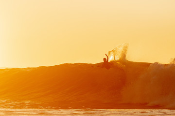 silhouette of a surfer on a wave.