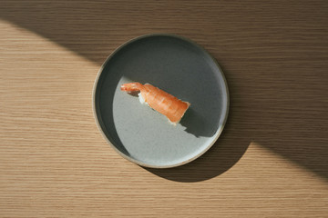 Shrimp sushi nigiri on dish over blue.