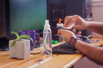 man disinfecting your phone  with alcohol in a homeoffice