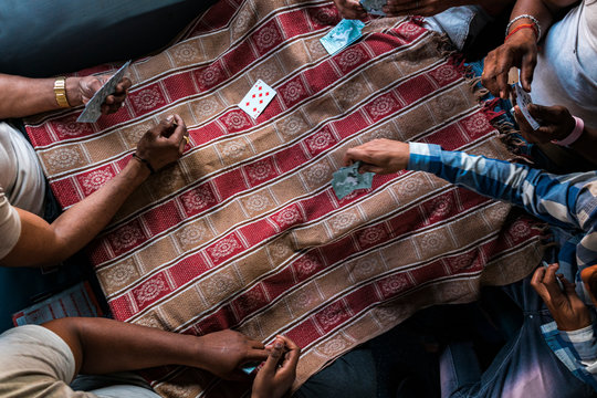 Crop people playing cards in train