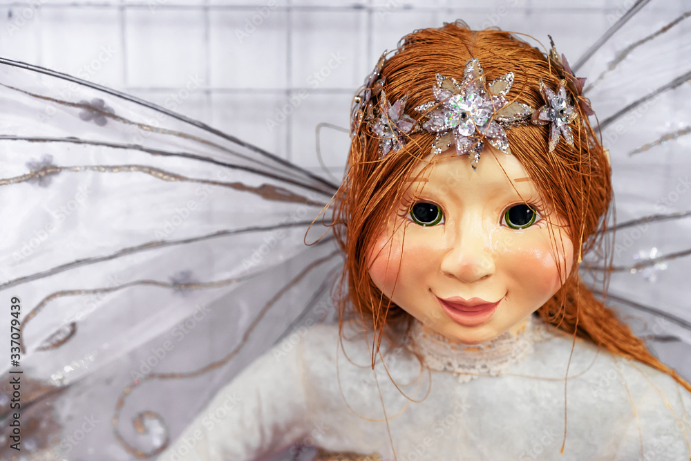 Wall mural Doll with red hair and a diadem. Realistic doll with dragonfly wings.