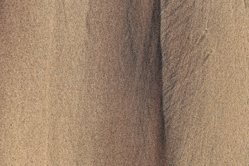 The texture of sea sand with traces of smudges