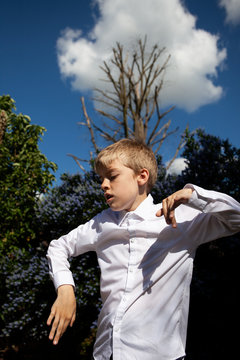 Boy dancing in a garden.