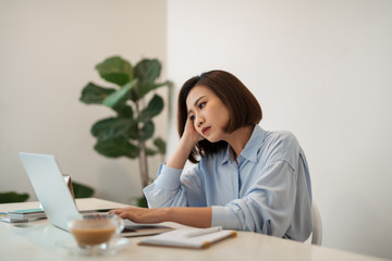 Concentrated business woman working on laptop at office