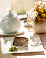 chocolate crepe cake slice with white cream