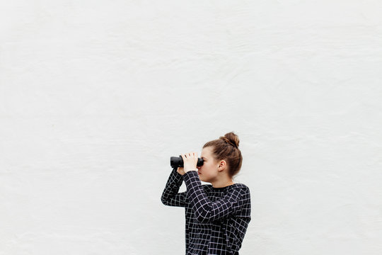 Profile of preteen girl looking through binoculars