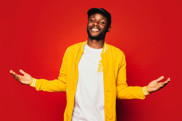 Happy young black man looking at camera over a red background