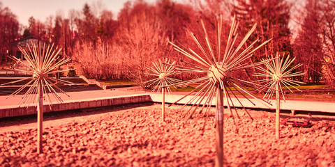 These objects resemble a coronavirus. Photo with red filter. It's an old Soviet fountain