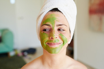 Beautiful woman with green face mask.