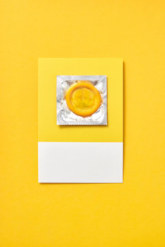 Colored condom on a yellow background.